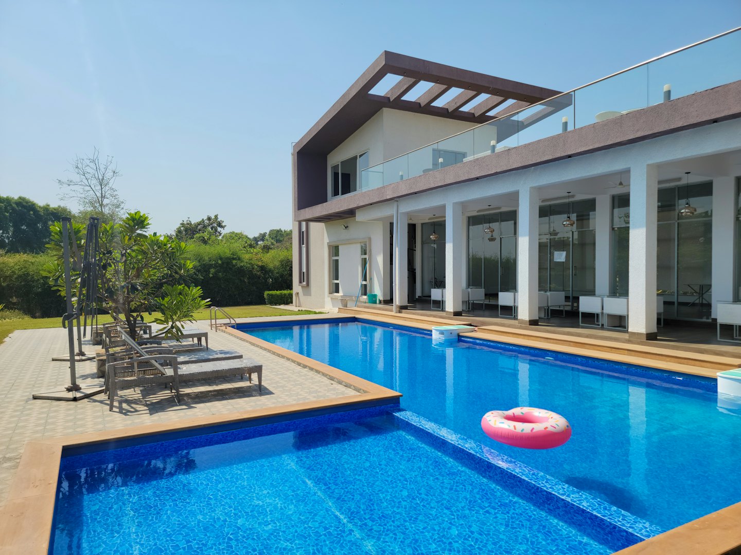 Moderne Villa mit Pool und pinkfarbenem Donut-Schwimmring.